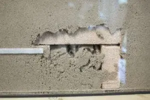 A concrete block is buried under sand.