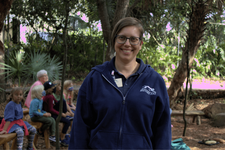 Andrea Aubert smiles at the camera while a class takes place behind her.