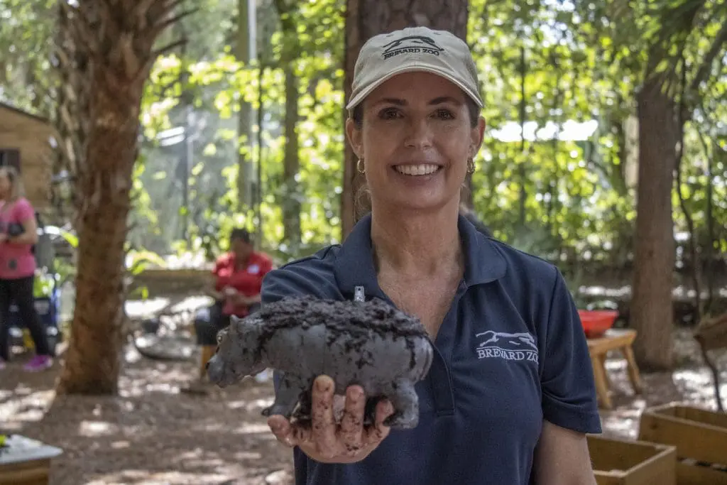 Kristen Gunderson holds out a muddy rhino