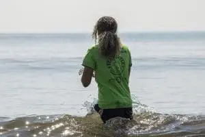 Nephron the green sea turtle is held by a Sea Turtle Healing Center staff member