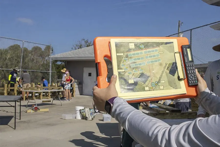 Construction of a seagrass nursery begins as a staff member holds up a blueprint.