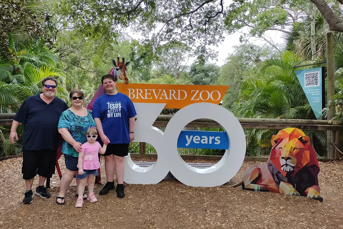 family in front of the Brevard Zoo 30 years sign