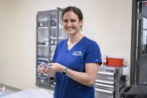 A woman holds a baby sea turtle.