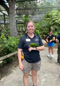 A lorikeet perches on a woman's arm.