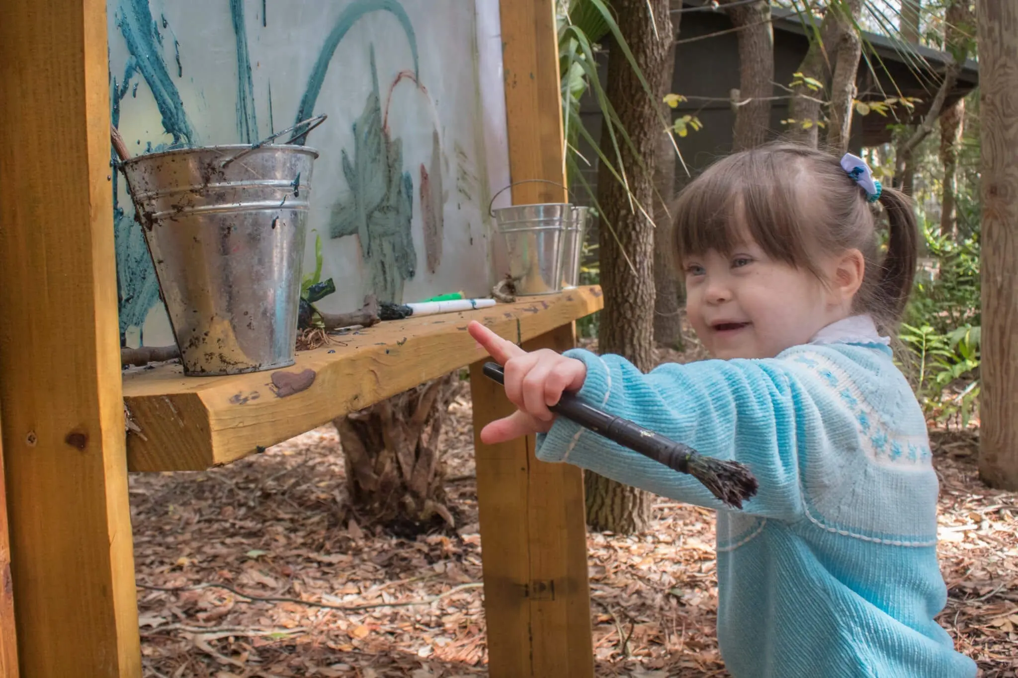 Young girl paints with mud