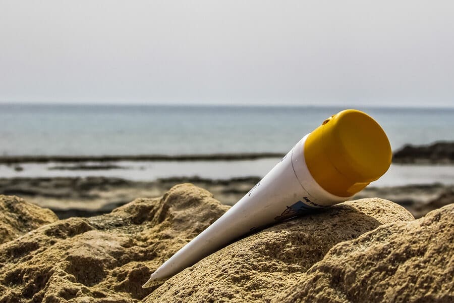 Bottle of sunscreen on the beach.