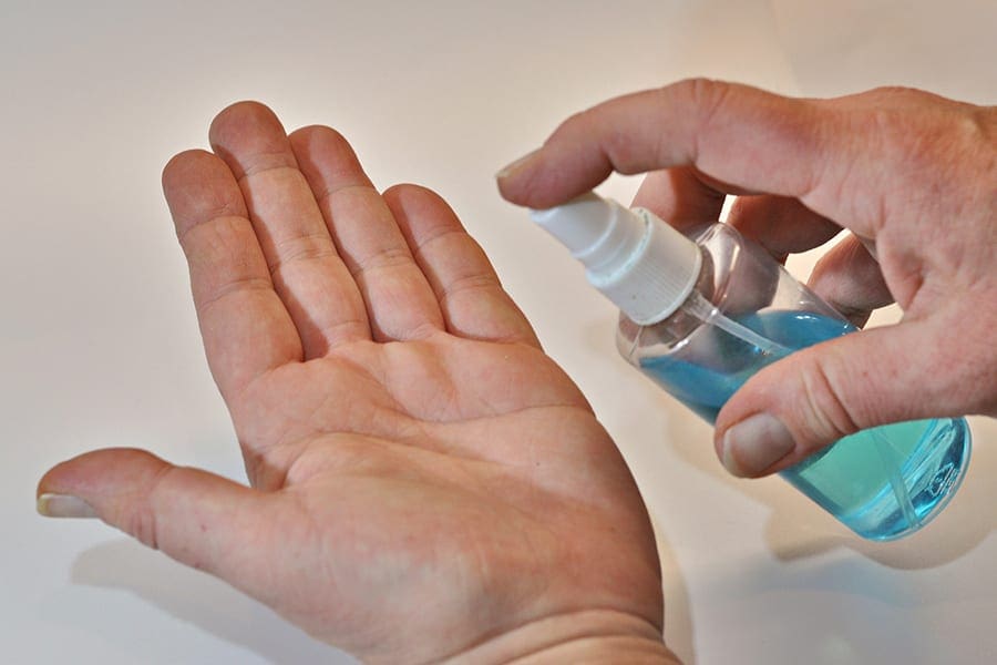 Spraying disinfectant on hands