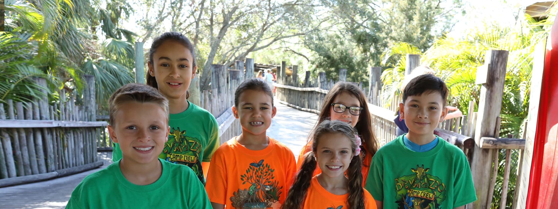 A group of young students smiling at the Zoo.