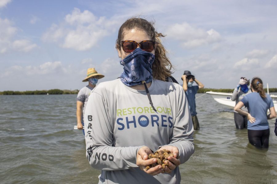 A Restore Our Shores team member holds clams.