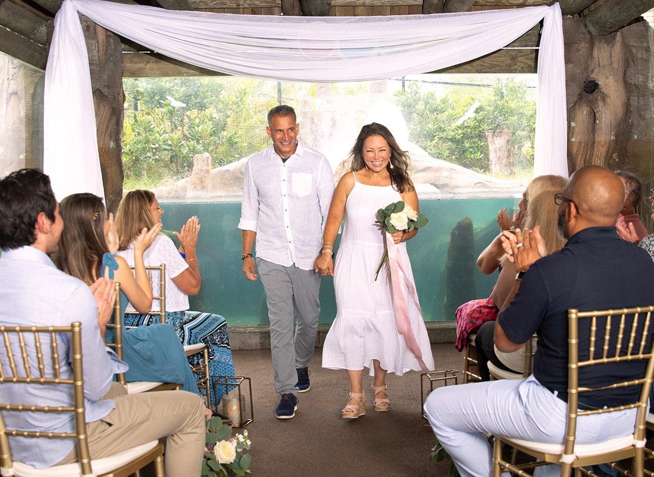 couple getting married in front of giant river otters