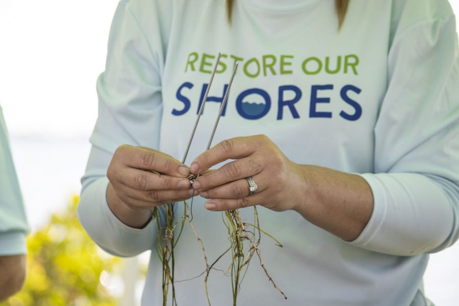 A volunteer twirls seagrass around floral wire.
