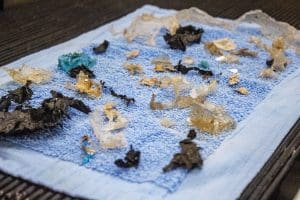 Pieces of plastic lay on a blue towel. 