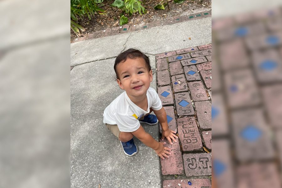 young boy next to his mom's 30 year old brick in the path at Brevard Zoo