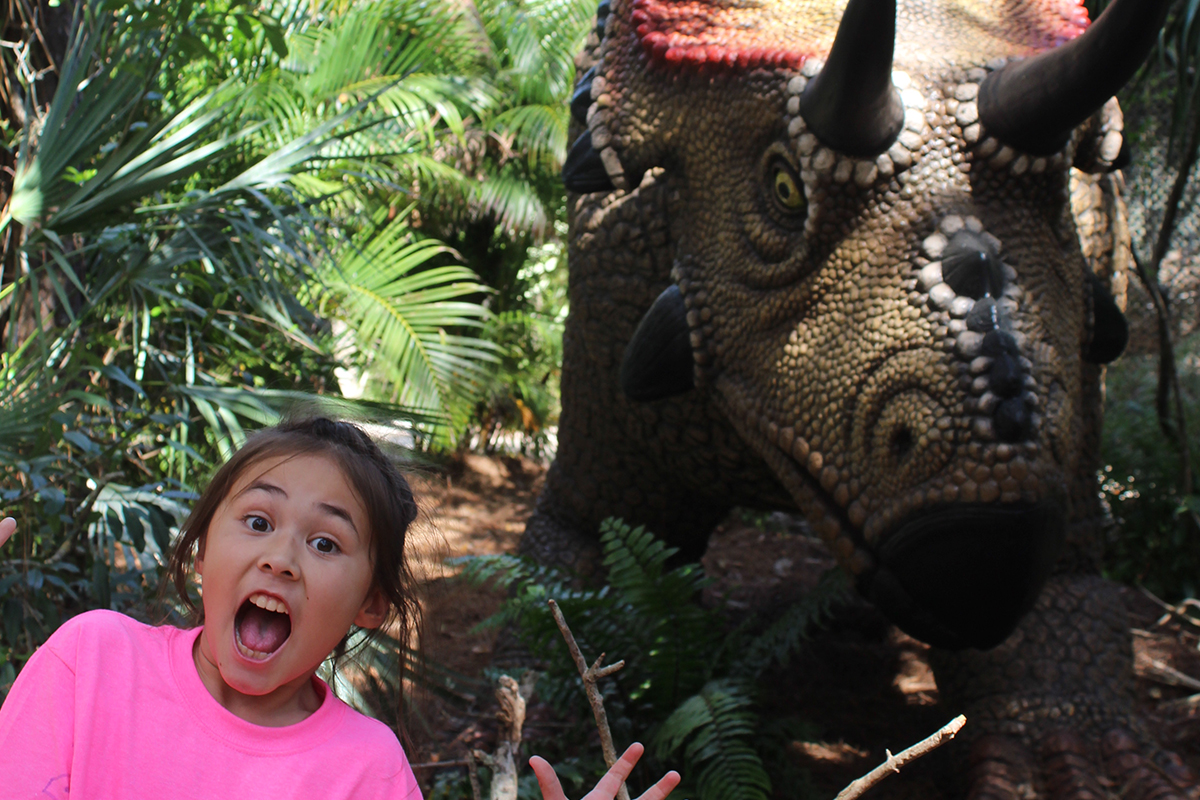 girl acting scared in front of a diabloceratops