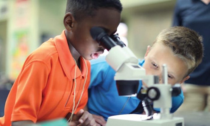 young boy looking in a microscope