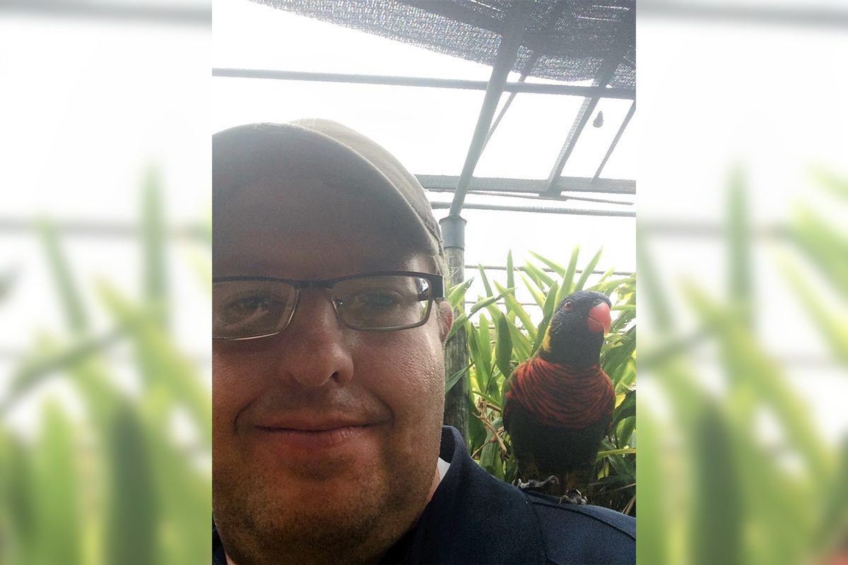 Steve H in aviary with a bird on his shoulder