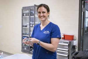 A woman holds a baby sea turtle.