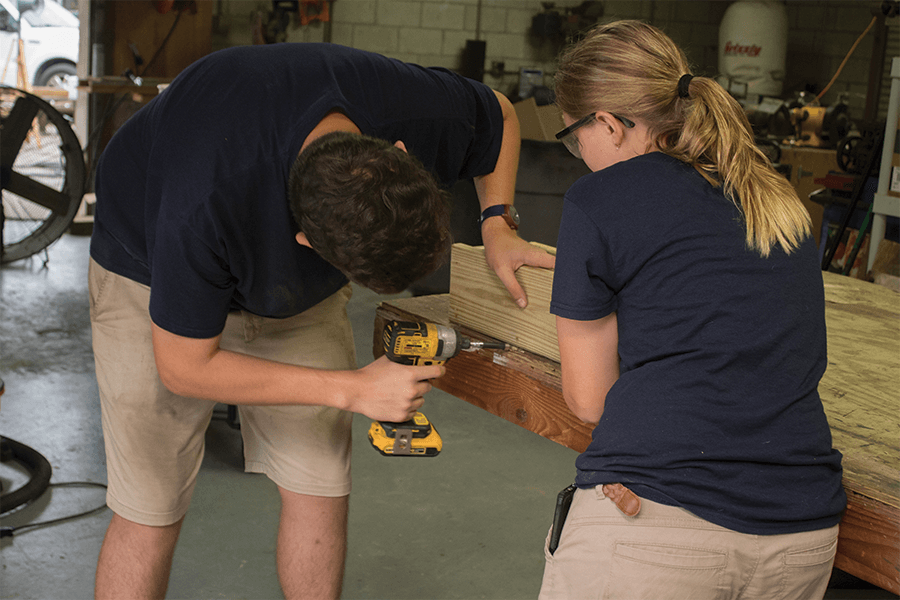 Maintenance interns constructing wooden frame