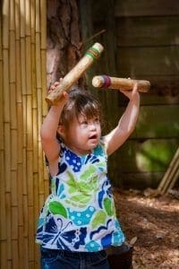 Girl playing with bamboo wind chime
